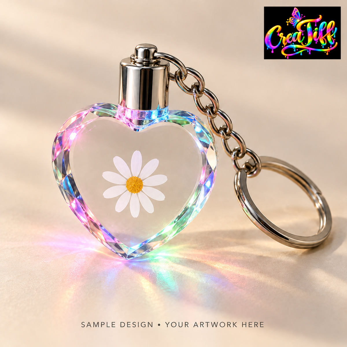 Illustrative sample of a clear heart-shaped LED crystal keychain with a daisy design; your artwork goes here. CreaTiff rainbow butterfly branding.